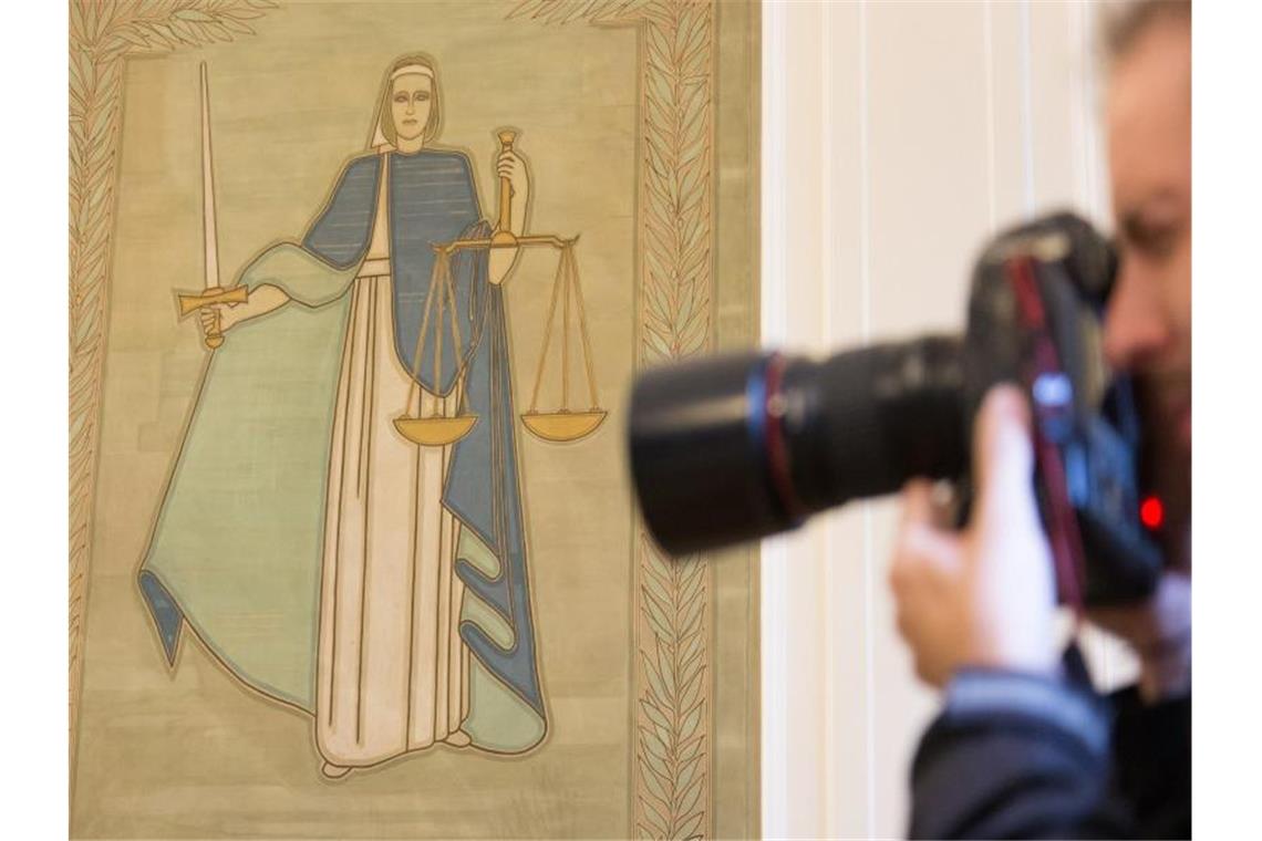 Ein Fotograf vor dem Bild der Justitia. Foto: Friso Gentsch/Archiv