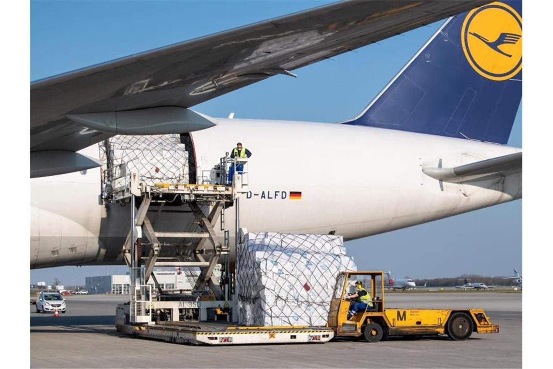 Ein Frachtflugzeug der Lufthansa Cargo wird auf dem Flughafen München entladen. Foto: Matthias Balk/dpa