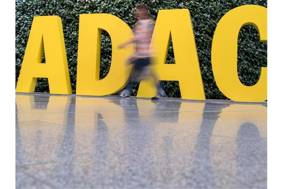 Ein Frau geht vor dem ADAC-Logo entlang. Foto: picture alliance / Peter Kneffel/dpa
