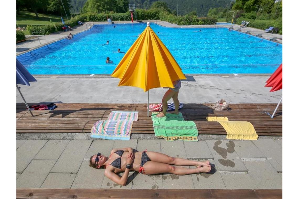 Ein Frau liegt im Freibad Zwiefalten auf einer Terrasse und sonnt sich. Foto: Thomas Warnack