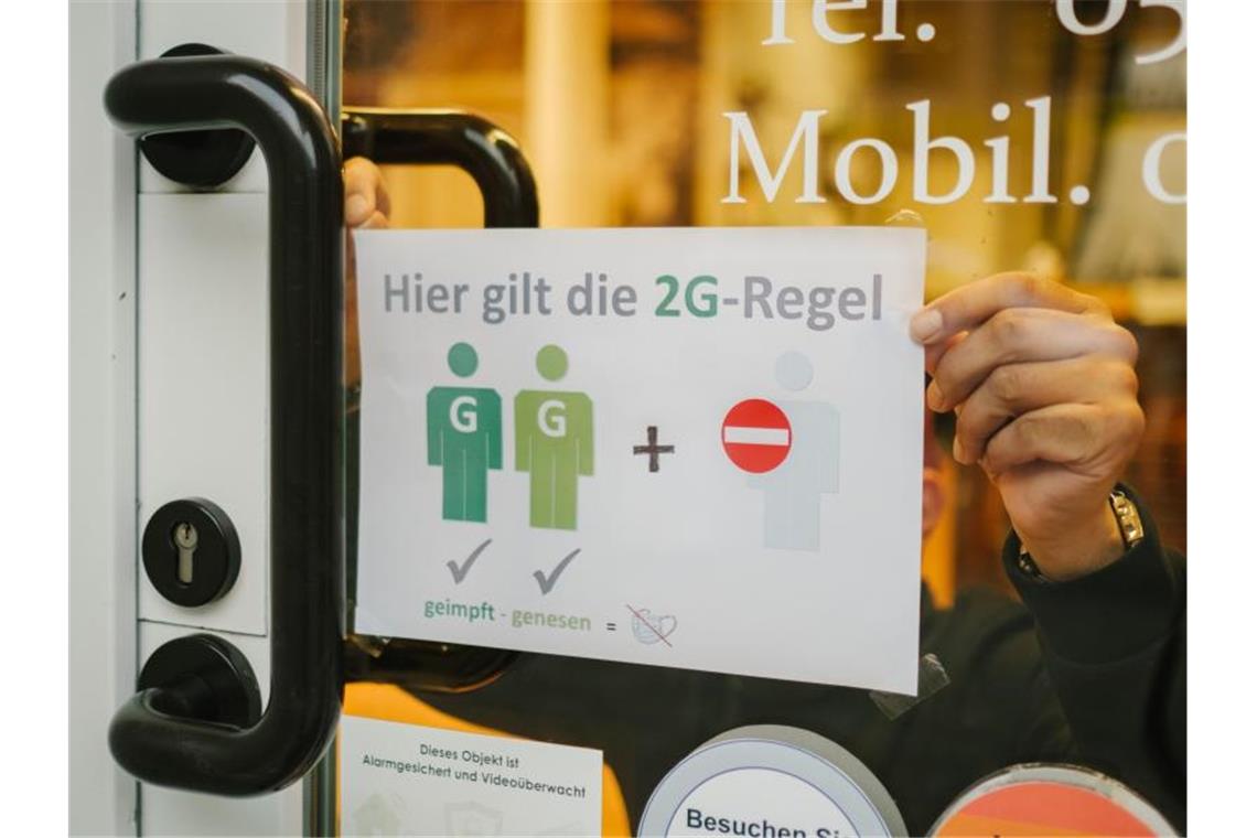 Ein Friseur in Hannover verweist in seinem Schaufenster auf die 2G-Regel. Foto: Ole Spata/dpa