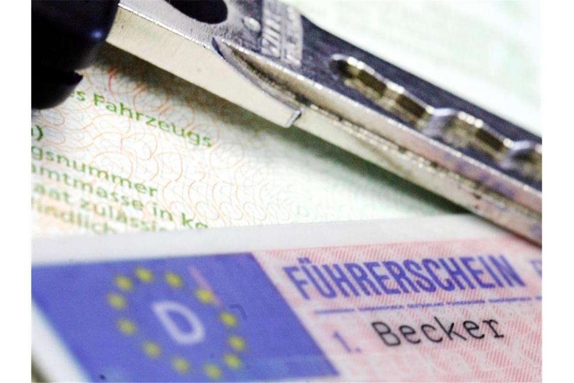 Schummeleien bei Theoriestunden: Anklage gegen Fahrlehrer Ein Führerschein und ein Autoschlüssel liegen auf einem Fahrzeugschein. Foto: Marius Becker/dpa/Symbolbild