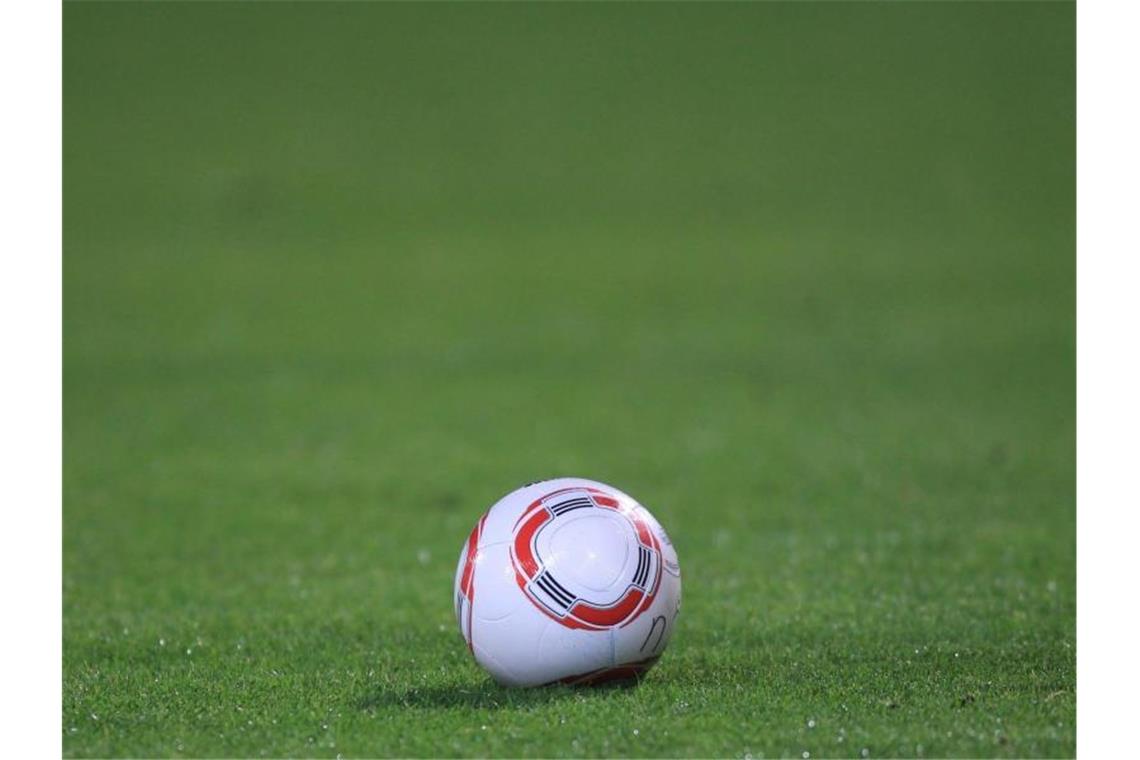Ein Fussball liegt auf dem Rasen. Foto: picture alliance / dpa / Archivbild