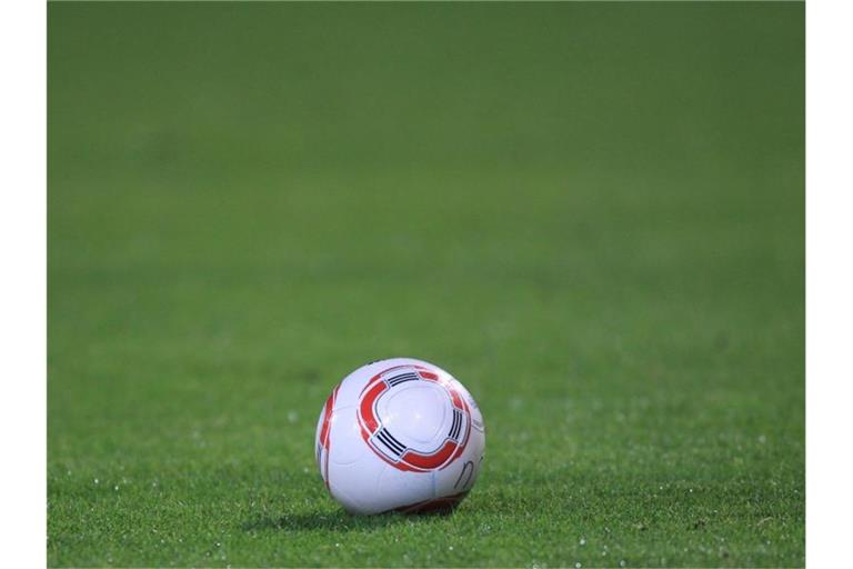 Ein Fussball liegt auf dem Rasen. Foto: picture alliance / dpa / Archivbild