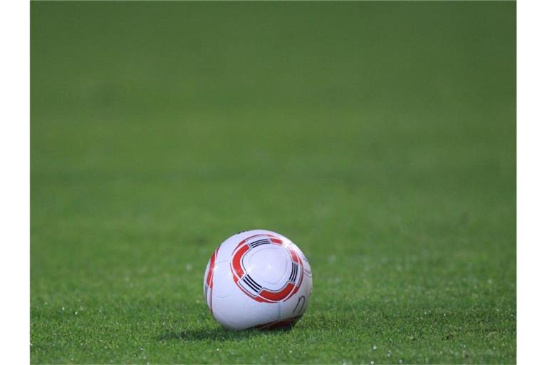 Ein Fussball liegt auf dem Rasen. Foto: picture alliance / dpa / Archivbild
