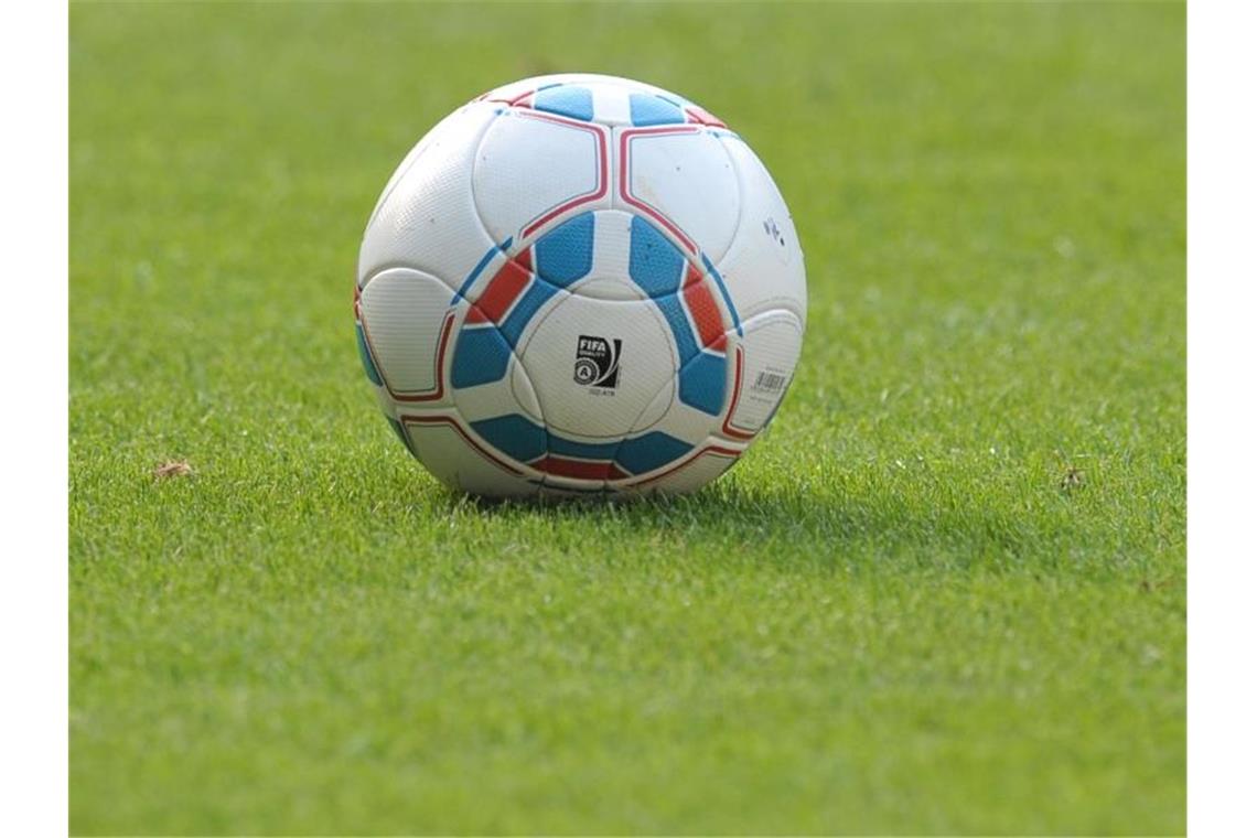 Ein Fußball liegt auf einem Spielfeld. Foto: picture alliance / dpa/Symbolbild