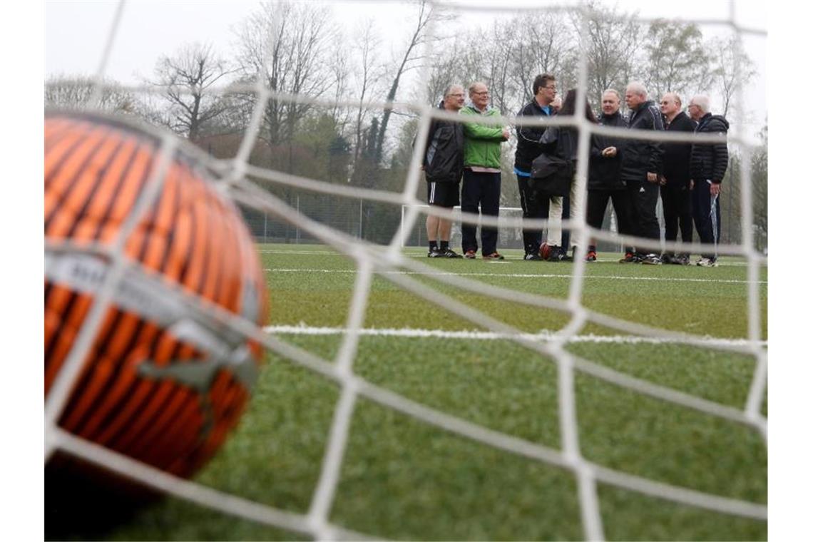 Ein Fußballteam bespricht sich auf dem Kunstrasenplatz. Foto: Roland Weihrauch/Archivbild