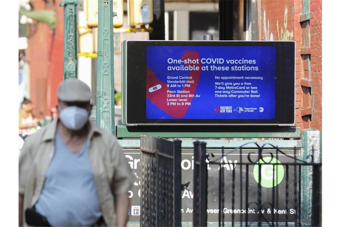 Ein Fußgänger geht an einer Werbetafel für Corona-Schutzimpfungen an einer New Yorker U-Bahn-Station vorbei. Foto: Wang Ying/XinHua/dpa