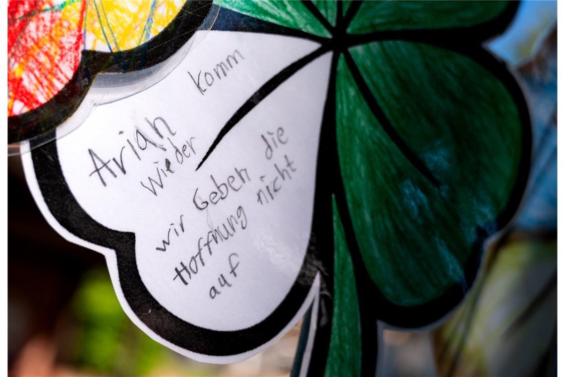 Ein gebasteltes Kleeblatt mit der Aufschrift „Arian komm wieder. Wir geben die Hoffnung nicht auf“ hängt an einem Zaun. Die Suche nach dem seit dem 22. April vermissten sechsjährigen Jungen Arian aus Bremervörde soll weitergehen.