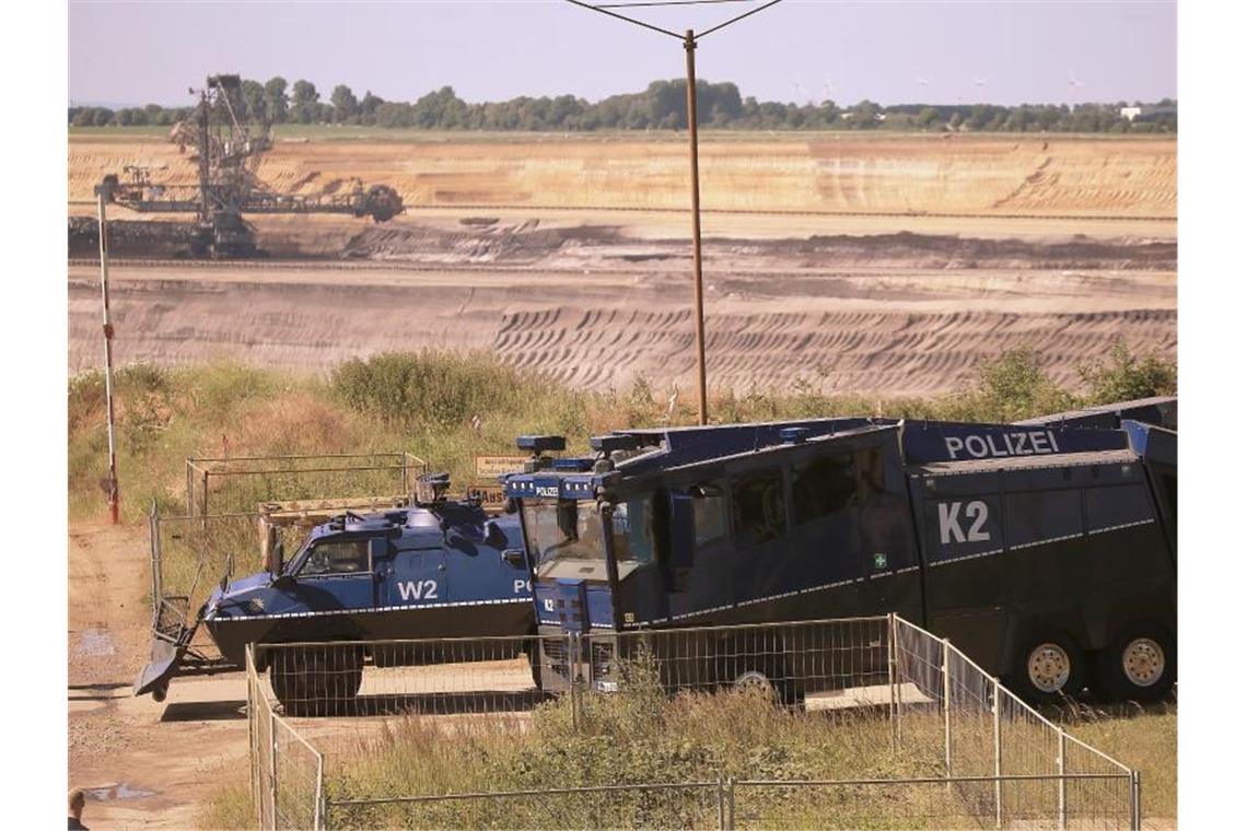 Ein gepanzertes Räumfahrzeug und ein Wasserwerfer am Rand des Braunkohle-Tagebaus Garzweiler. Foto: David Young