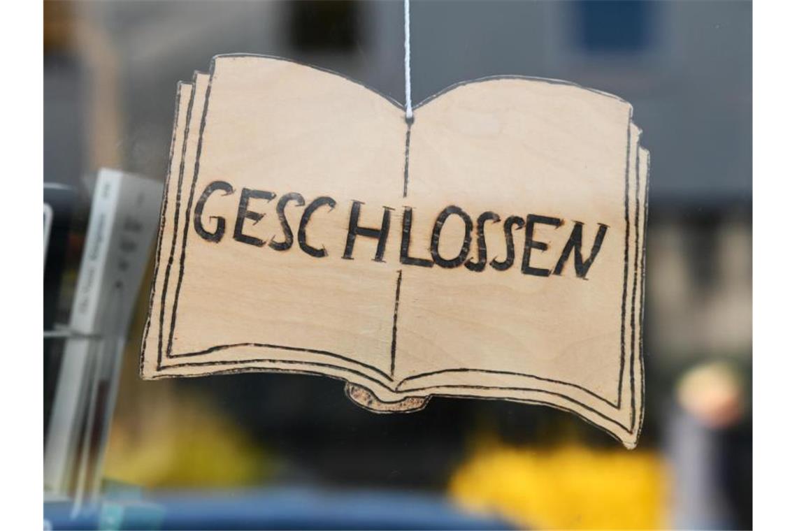 Ein „Geschlossen“-Schild vor einer Buchhandlung. Foto: Uwe Zucchi/dpa