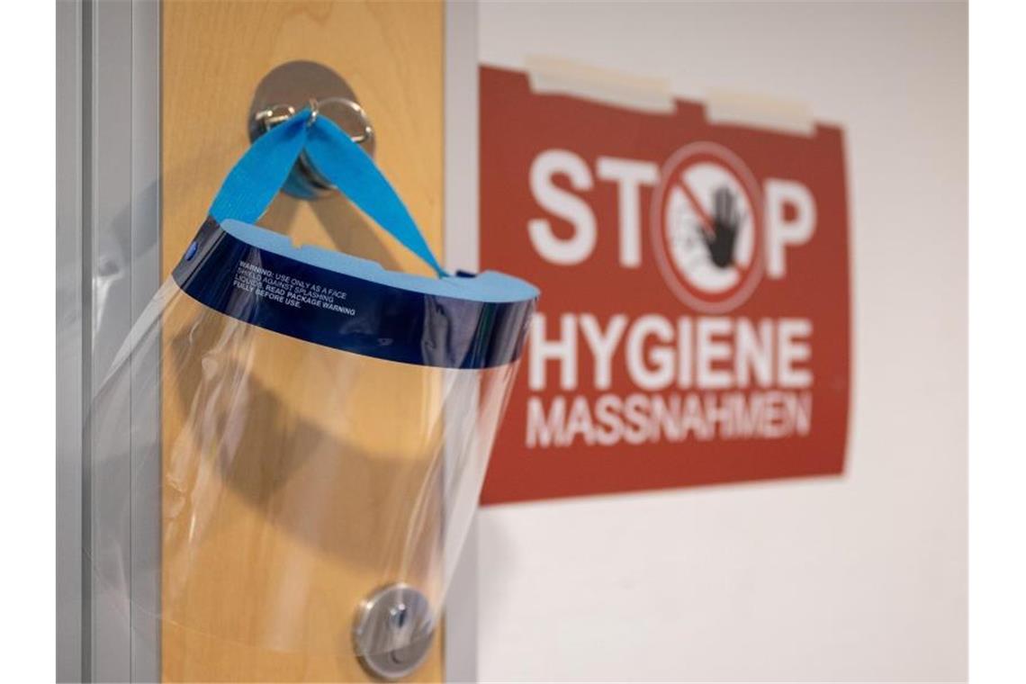Ungeimpfte müssen Anfang September mit Eingriffen rechnen Ein Gesichtsschutz hängt neben einem Schild mit der Aufschrift „Stop Hygienemaßnahmen“. Foto: Sebastian Gollnow/dpa