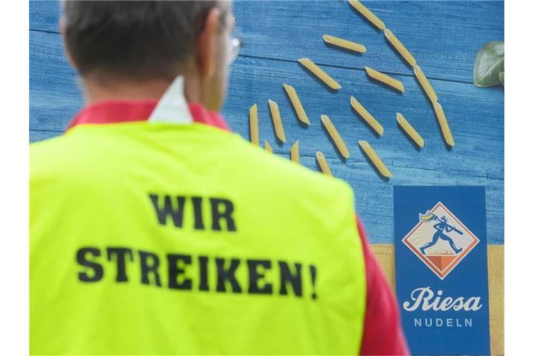 Ein Gewerkschaftsmitarbeiter steht während eines Streiks vor dem Werk der Teigwaren Riesa GmbH. Foto: Robert Michael/dpa-Zentralbild/dpa
