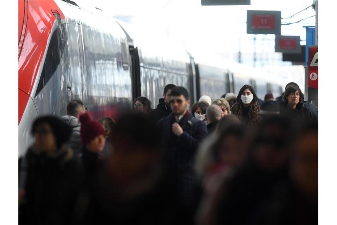Ein Gleis am Hauptbahnhof von Mailand - einige Menschen tragen Gesichtsmasken. Foto: Daniele Mascolo/XinHua/dpa