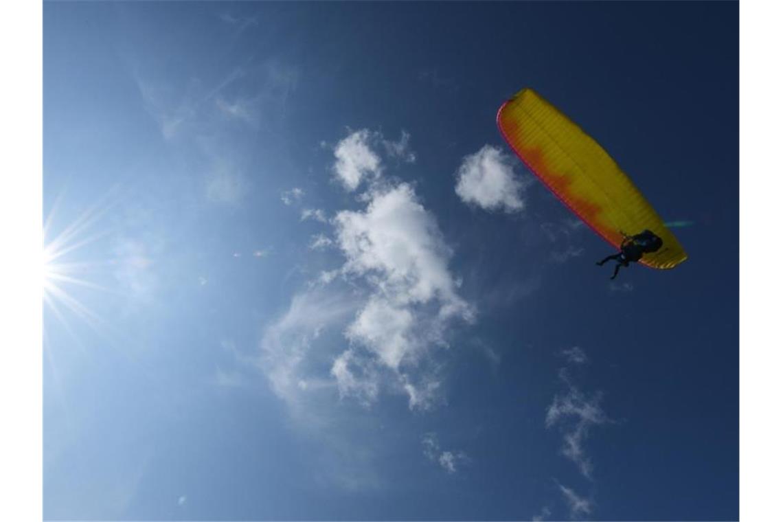 Ein Gleitschirmflieger startet bei sonnigem Wetter. Foto: Angelika Warmuth/dpa/Symbolbild