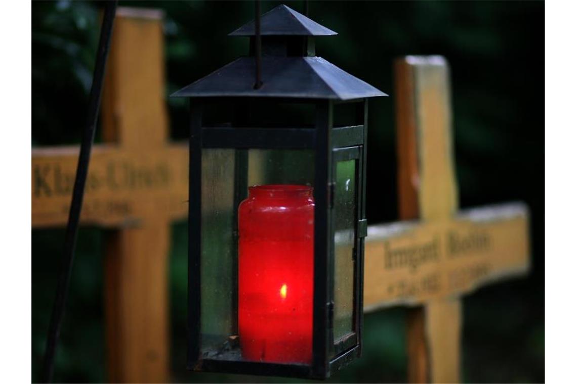 Ein Grablicht leuchtet auf einem Friedhof. Foto: Heiko Lossie/dpa/Symbolbild