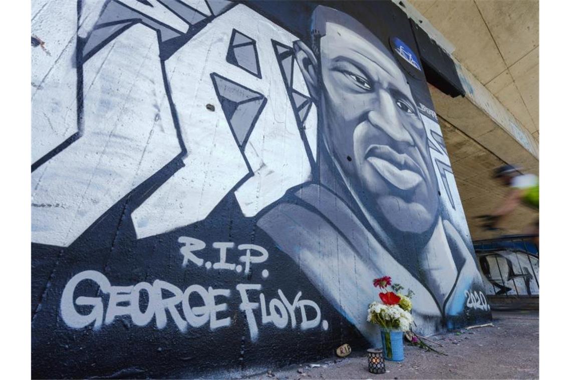 Ein Graffiti, Kerzen, Blumen und Steine zum Gedenken an George Floyd in Mannheim. Foto: Uwe Anspach/dpa