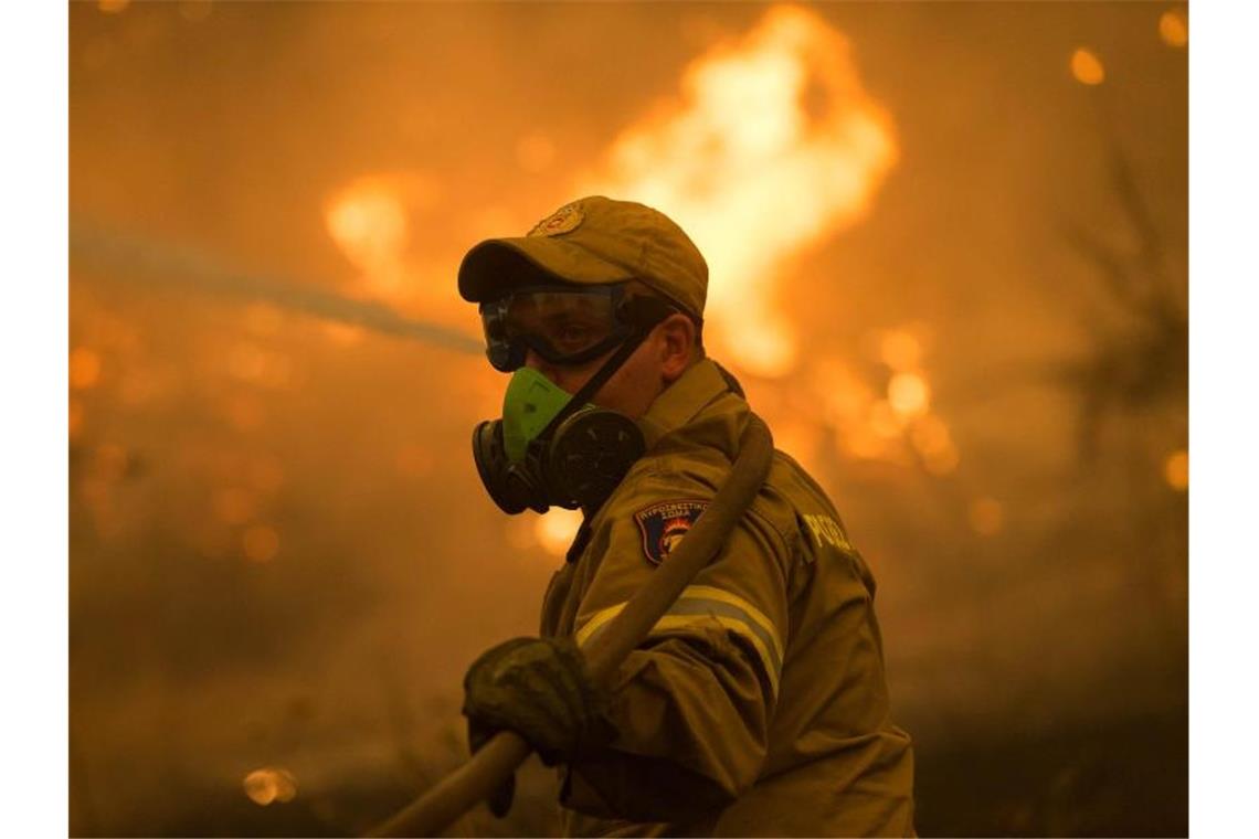 Ein griechischer Feuerwehrmann im Kampf gegen die Flammen. Foto: Marios Lolos/XinHua/dpa