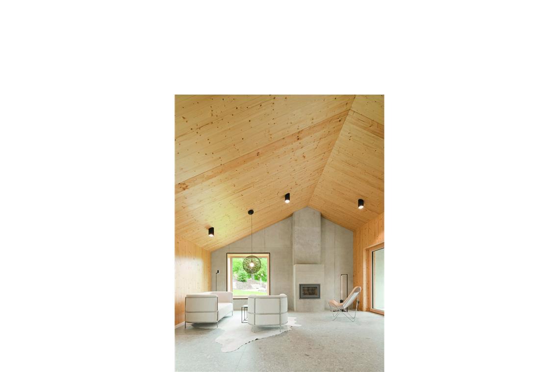 Die besten einfachen Häuser Europas – auch von Stuttgarter Architekten Ein großer Raum mit viel Holz: Wohnbereich des von Rolf Klärle entworfenen Hauses mit großem quadratischen Fenster, bodentiefer Terrassentür und Kamin.