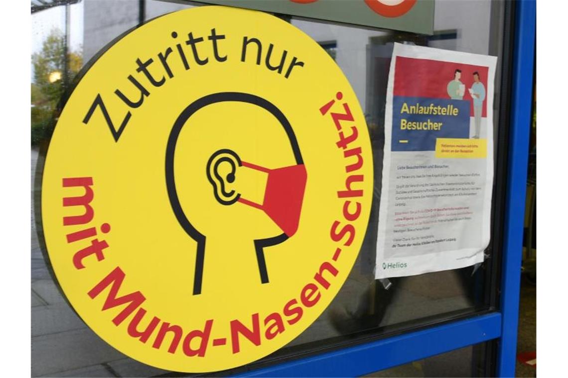 22.461 neue Corona-Infektionen Ein großes Schild weist neben einem Eingang zu einer Klinik in Leipzig auf die Maskenpflicht hin. Foto: Waltraud Grubitzsch/dpa