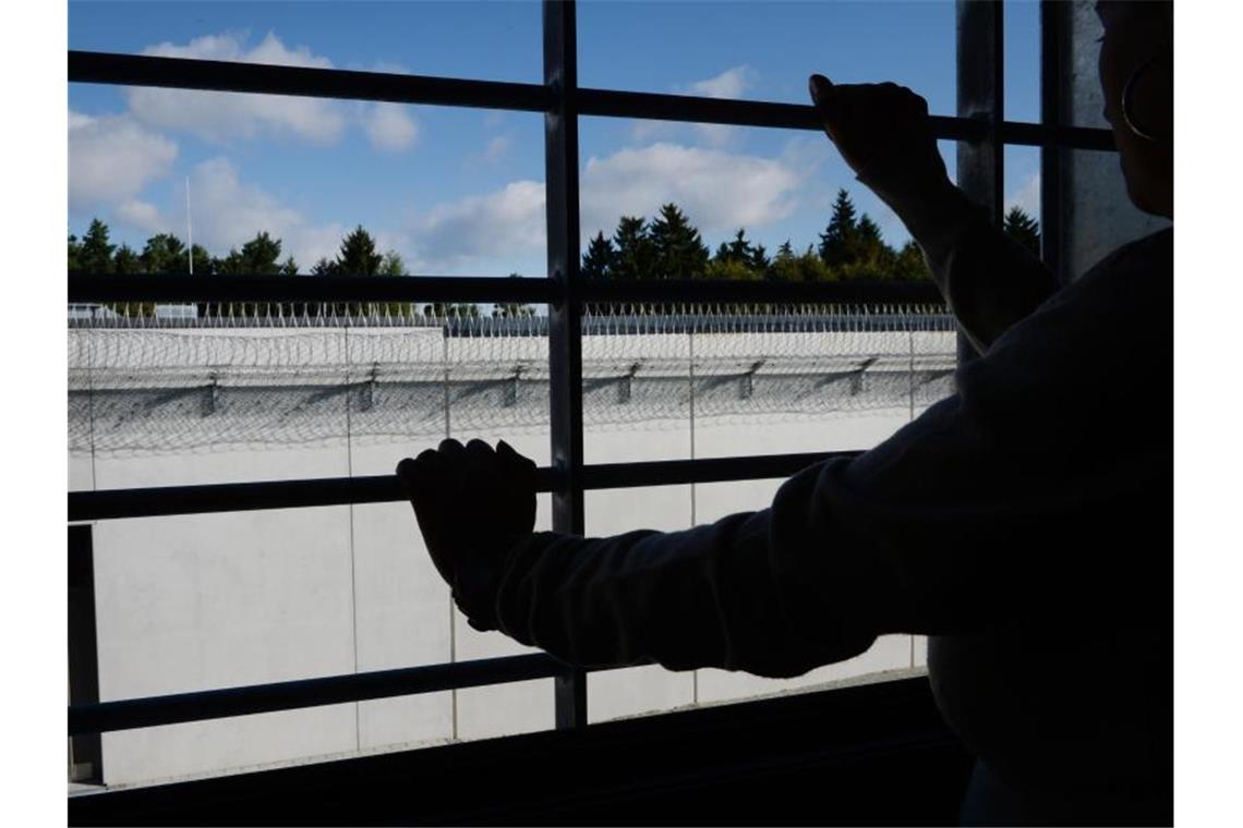 Ein Häftling steht an einem vergitterten Fenster in einer Zelle. Foto: Felix Kästle/dpa