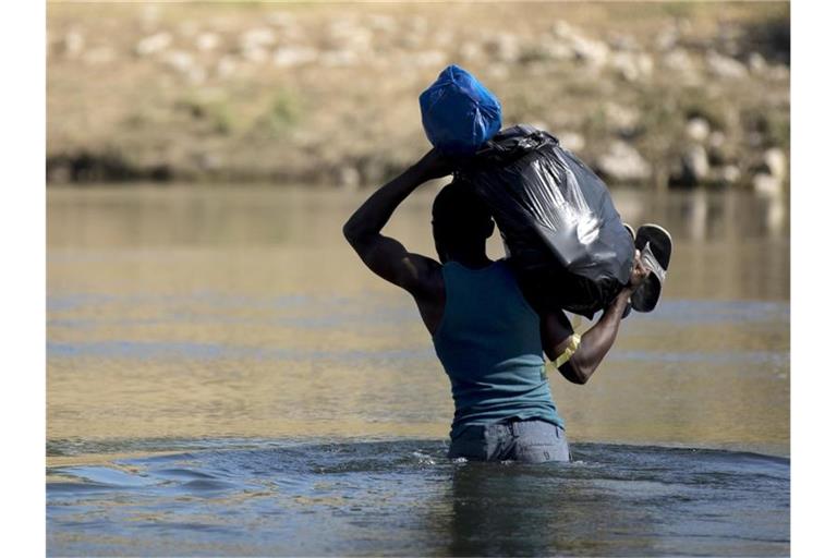 Ein haitianischer Migrant versucht den Fluss Rio Grande von Mexiko in die USA zu überqueren. Foto: Nick Wagner/XinHua/dpa
