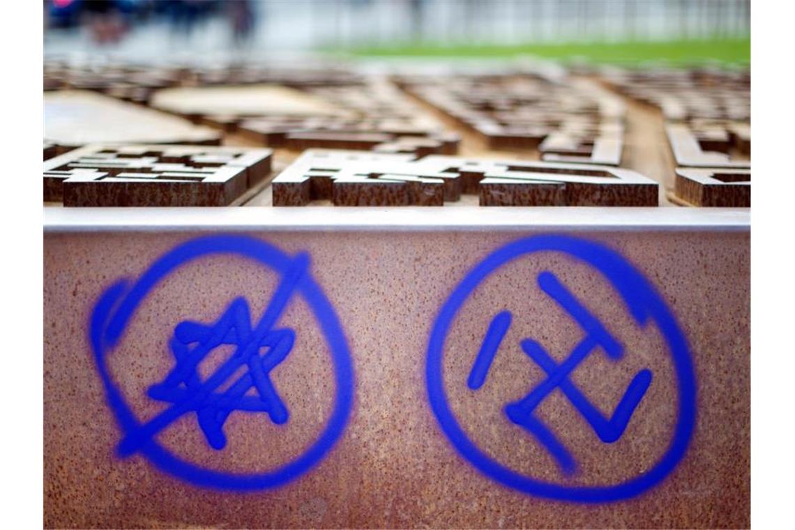 Ein Hakenkreuz und ein durchgestrichener Davidstern sind an einer Gedenkstätte zu sehen. Foto: Daniel Reinhardt/dpa