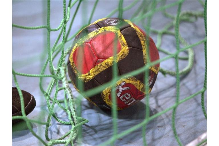 Ein Handball liegt im Netz. Foto: Rainer Jensen/dpa/Archivbild