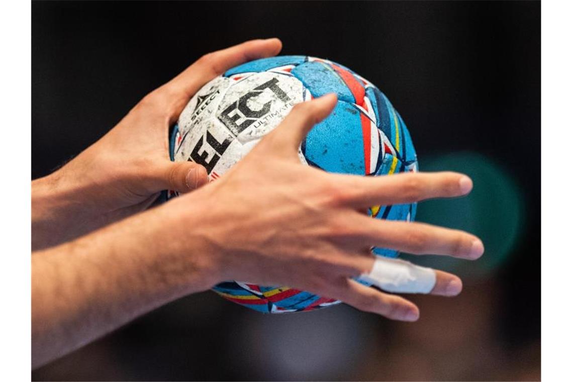 Ein Handballer hält einen Handball in den Händen. Foto: Robert Michael/dpa/Symbolbild