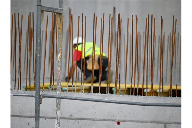 Ein Handwerker arbeitet auf einer Baustelle an Betonstahlträgern. Foto: Patrick Seeger/dpa