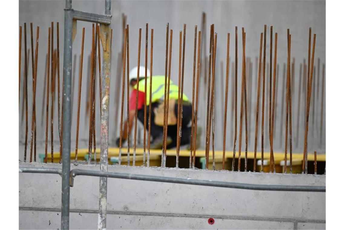 Ein Handwerker arbeitet auf einer Baustelle an Betonstahlträgern. Foto: Patrick Seeger/dpa/Symbolbild