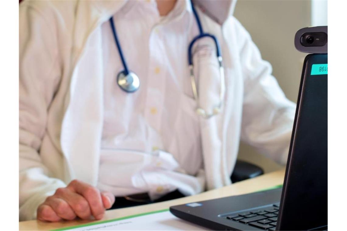 Mehr Praxisärzte - Durchschnittsalter steigt nicht weiter Ein Hausarzt sitzt während einer Videosprechstunde in seiner Praxis vor einem Laptop. Foto: Monika Skolimowska/ZB/dpa