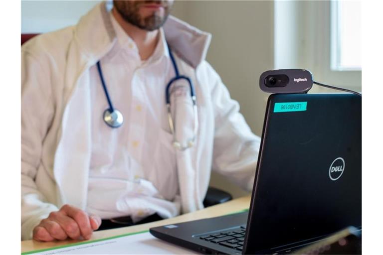Ein Hausarzt spricht während einer Videosprechstunde in seiner Praxis mit einer Patientin. Foto: Monika Skolimowska