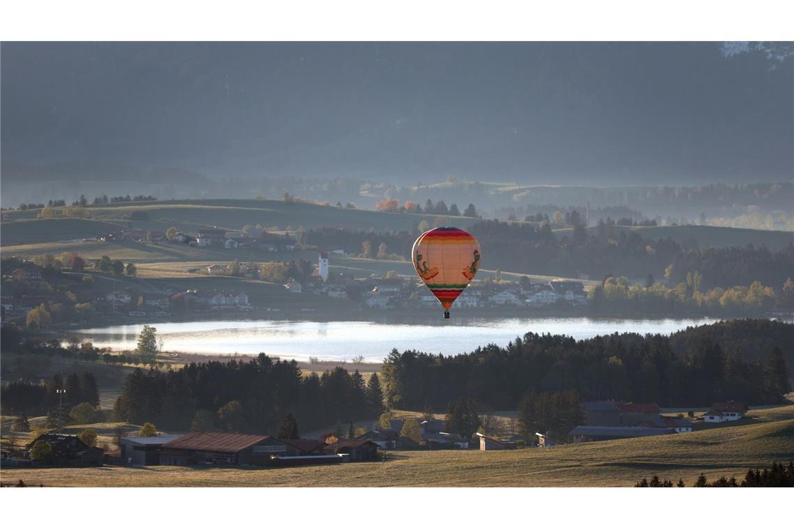 Ein Heißluftballon gleitet über den Hopfensee im Allgäu.