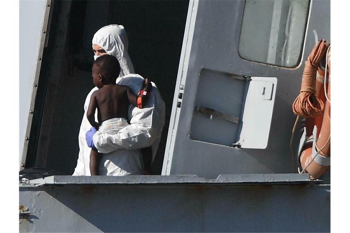 Italien droht hohe Geldstrafen für Rettung von Migranten an Ein Helfer bringt ein kleines Kind in Genua an Land: Leben retten soll in Italien künftig mit hohen Geldstrafen geahndet werden. Foto: Luca Zennaro/ANSA/AP
