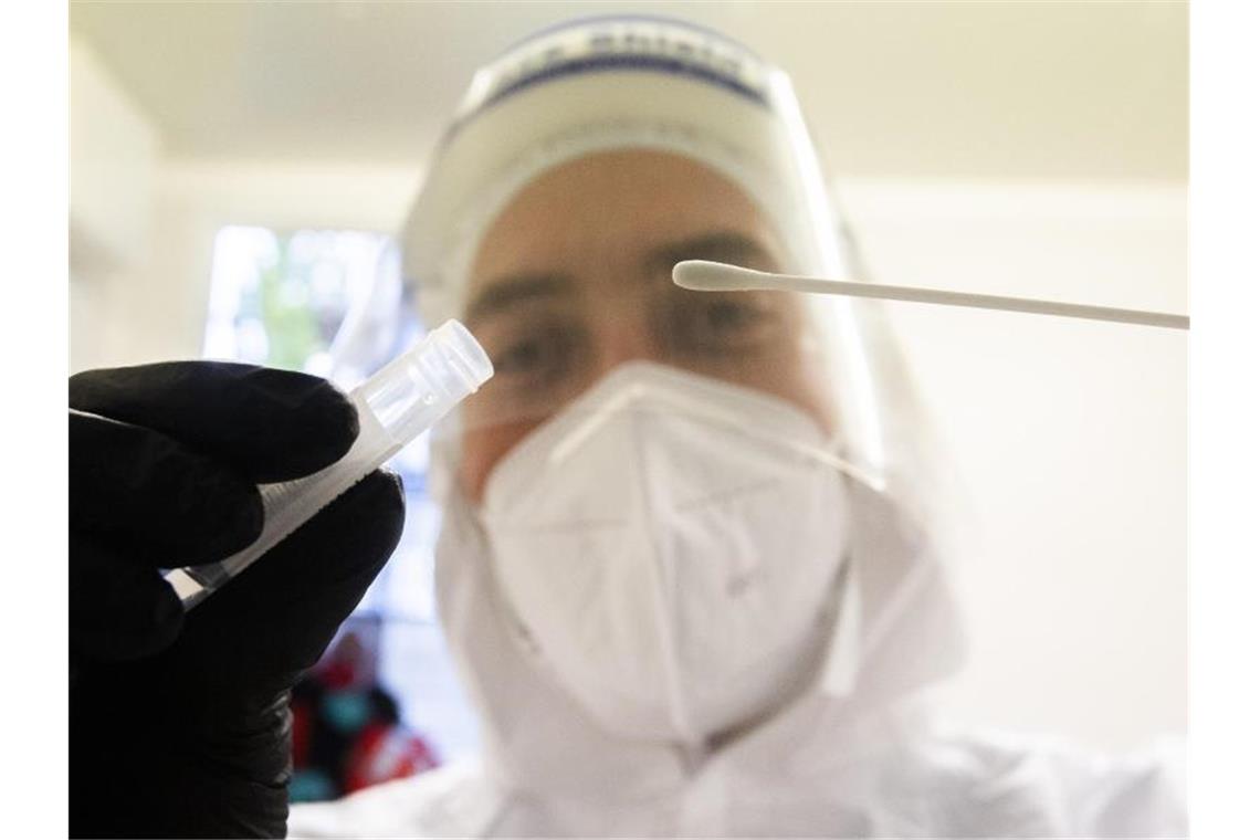 Grenzwert bei Corona-Neuinfektionen pro Woche überschritten Ein Helfer der Johanniter hält im Corona Testzentrum am Flughafen Hannover ein Teststäbchen. Foto: Julian Stratenschulte/dpa
