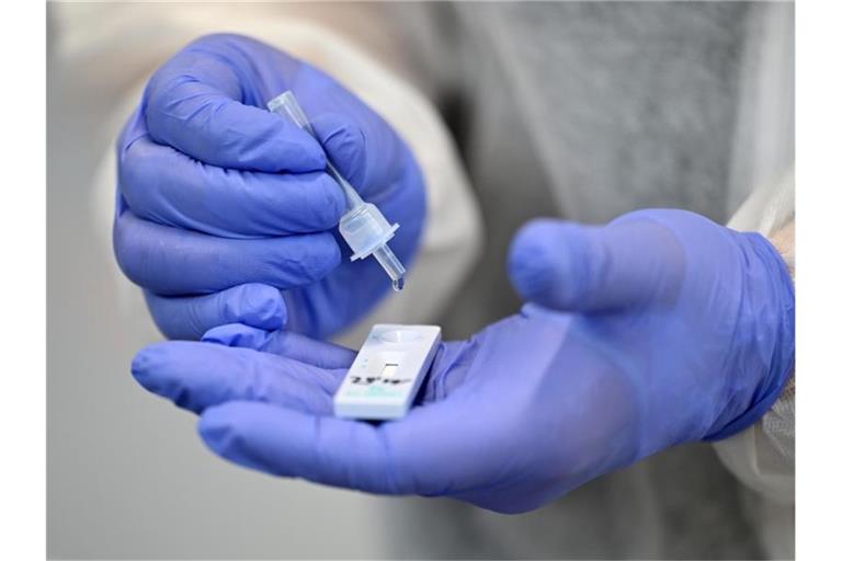 Ein Helfer verarbeitet eine Probe für einen Corona-Schnelltest im Staatlichen Berufsbildenden Schulzentrum Hildburghausen. Foto: Martin Schutt/dpa-Zentralbild/dpa