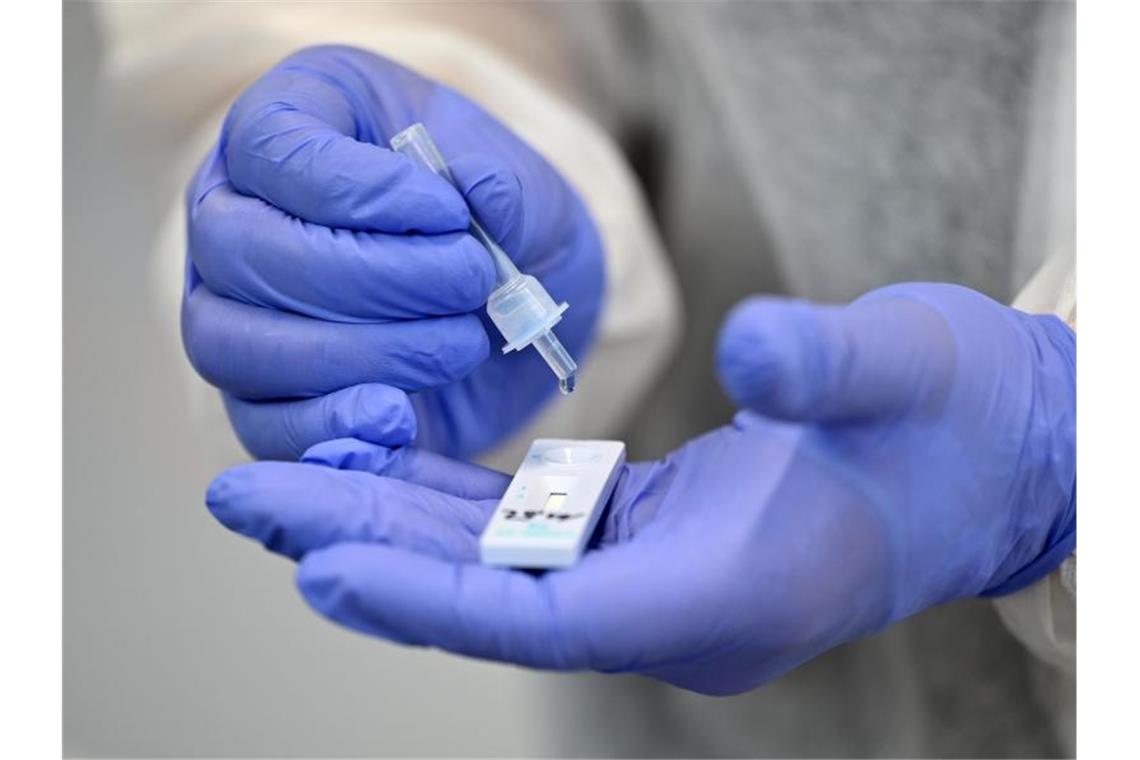 Antigentests erkennen Omikron genau wie frühere Varianten Ein Helfer verarbeitet eine Probe für einen Corona-Schnelltest (Symbolbild). Foto: Martin Schutt/dpa-Zentralbild/dpa
