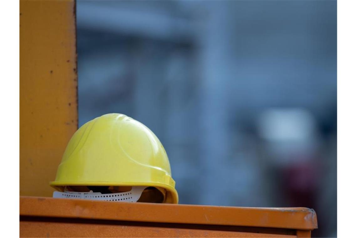 Ein Helm liegt auf einer Baustelle auf einem Kasten. Foto: Sebastian Gollnow/dpa/Archivbild