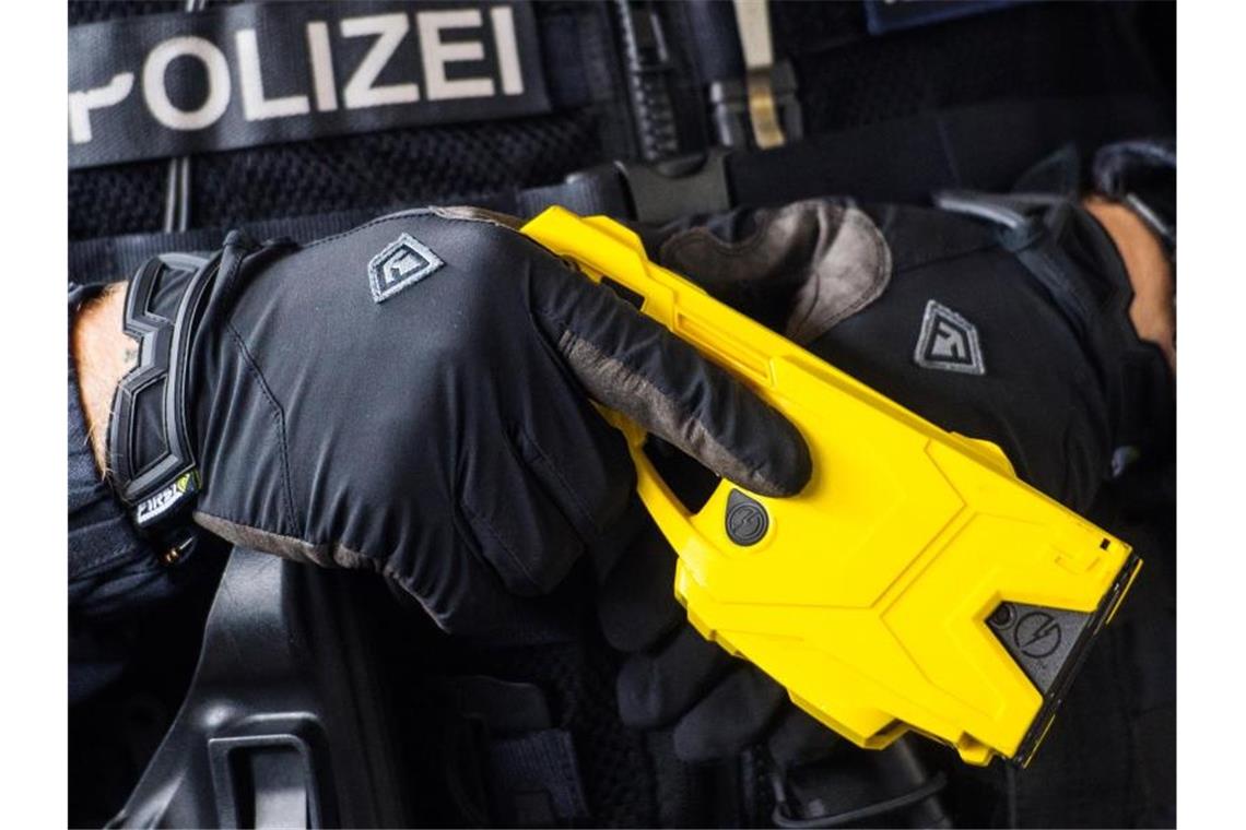 Ein hessischer Polizeibeamter hält einen Taser. Foto: Andreas Arnold/dpa