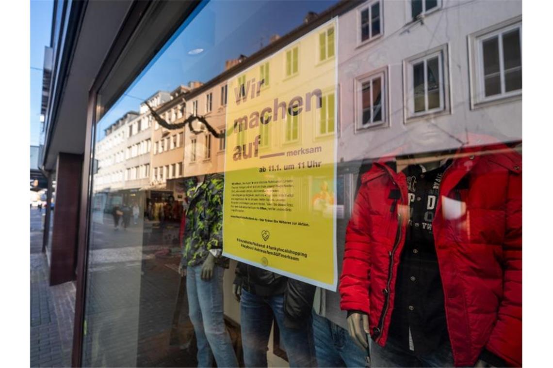 Händler protestieren gegen Ladenschließung Ein Hinweisschild der Aktion „Wir machen aufmerksam“ hängt am Eingang eines Bekleidungsgeschäfts in der Trierer Innenstadt. Foto: Harald Tittel/dpa