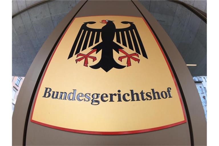 Ein Hinweisschild mit Bundesadler am Bundesgerichtshof. Foto: Uli Deck/Archivbild