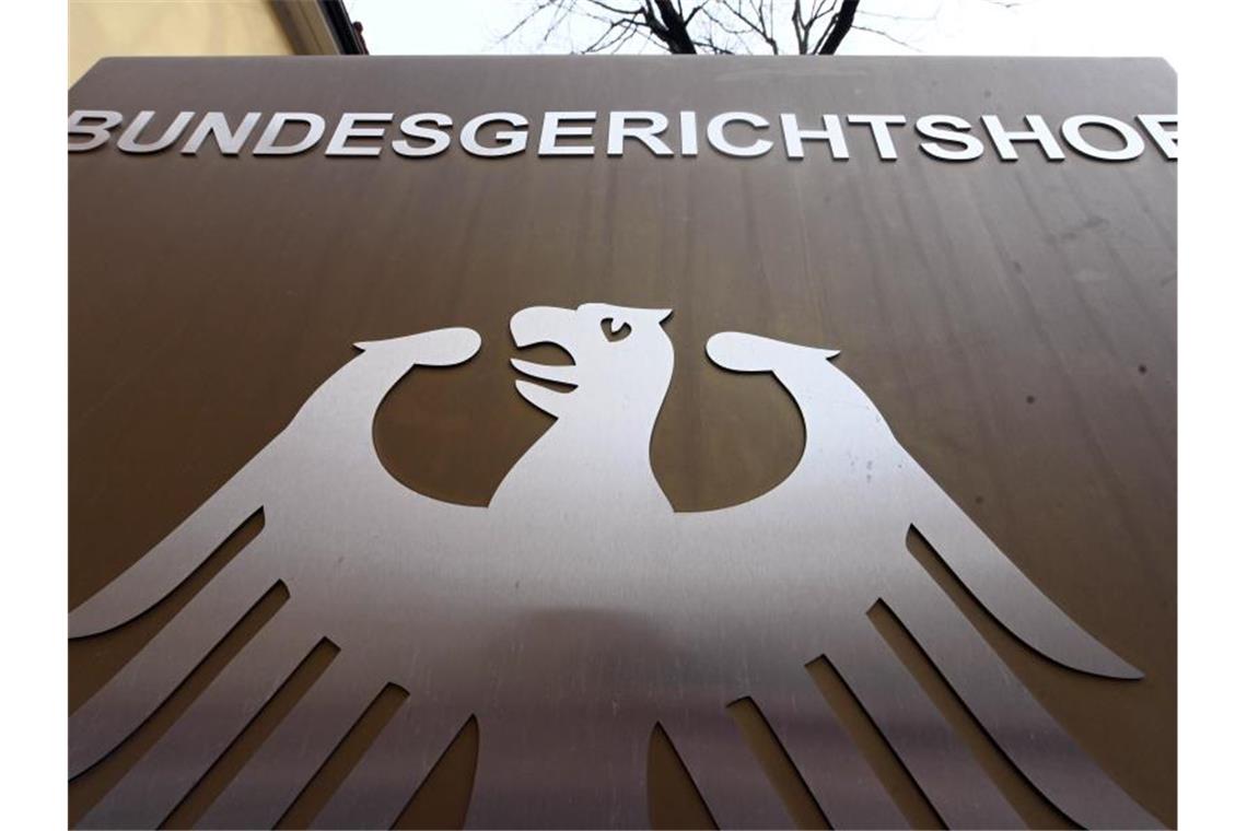 Ein Hinweisschild mit Bundesadler und Schriftzug Bundesgerichtshof vor dem BGH in Karlsruhe. Foto: Uli Deck/dpa/archivbild