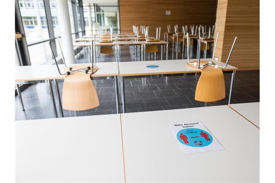 Ein Hinweisschild mit der Aufschrift „Bitte Abstand halten - mind. 1,5m Meter“ klebt im Kreisgymnasium in Bad Krozingen auf einem Tisch. Foto: Philipp von Ditfurth/dpa