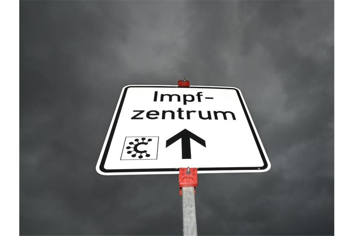 Ein Hinweisschild mit der Aufschrift „Impfzentrum“ und einem Covid-Logo ist nahe des Impfzentrums Heuchelheim zu sehen. Foto: Arne Dedert/dpa