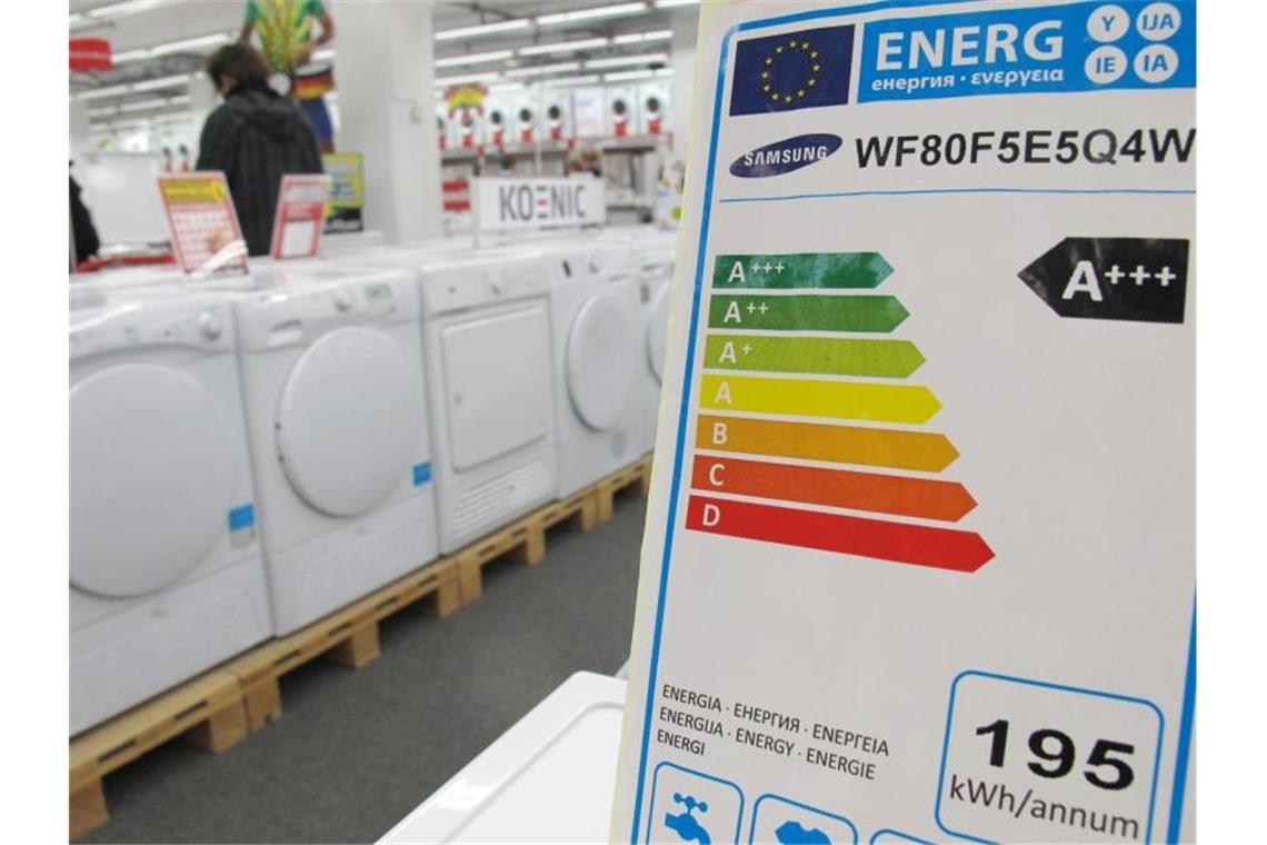 Ein Hinweisschild weist die Energieeffizienzklasse von Waschmaschinen aus. Foto: Peter Kneffel