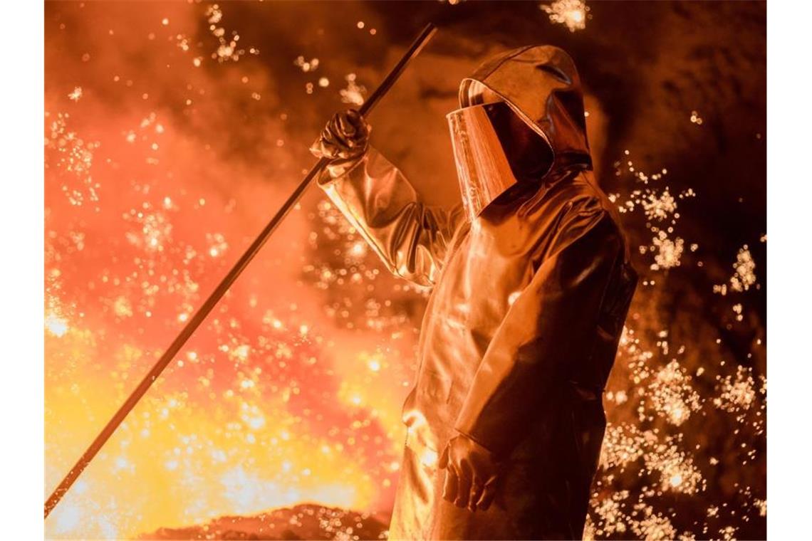 Ein Hochöfner arbeitet am Hochofen 2 im Werk Schwelgern von Thyssenkrupp. Stahl wird mit Kokskohle erzeugt, was enorme Mengen klimaschädlicher Abgase erzeugt. Foto: Rolf Vennenbernd/dpa