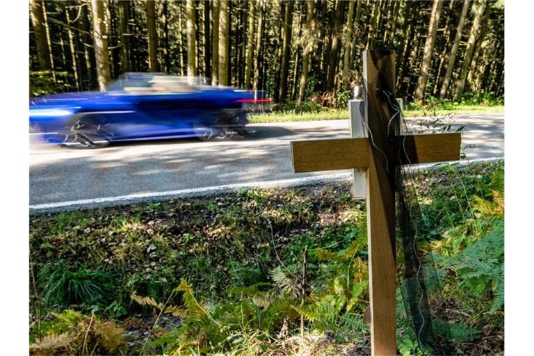 Ein Holzkreuz steht bei Achslach an der Stelle, an der die Männer bei einem Rennen den Tod eines weiteren Autofahrers verursacht haben sollen. Foto: Armin Weigel/dpa