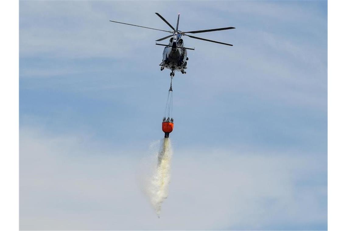 Ein Hubschrauber der Bundespolizei bekämpft mit Wasser einen Waldbrand. Foto: Patrick Pleul