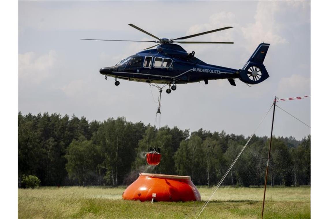 Ein Hubschrauber der Bundespolizei nimmt in Frankenförde Löschwasser auf. In Frankenförde bei Jüterbog befindet sich die Einsatzzentrale der Feuerwehr. Foto: Christoph Soeder